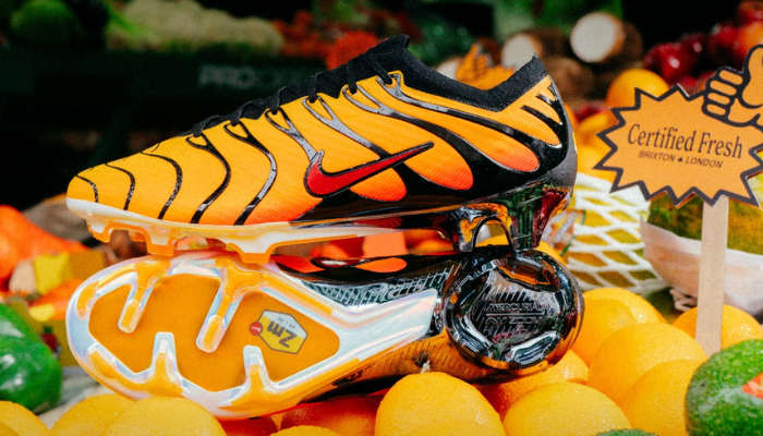 Chuteira de futebol Nike Mercurial Vapor 15 FG x Air Max Plus com a icônica base Pimento vermelha e detalhes em preto. A chuteira possui detalhes em cinza na placa da sola e cravos triangulares para melhor tração em gramado firme.